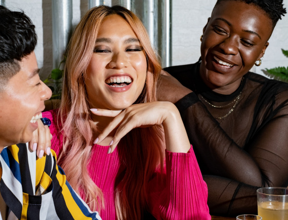 friends of varying genders laughing over drinks friends of varying genders laughing over drinks