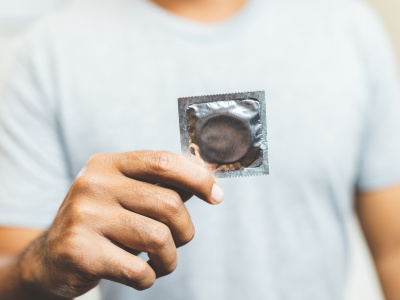 Male hand holding Condom. Safe sex concept.