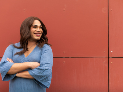 Transsexual woman on a red wall with happy face. Copy space background. High quality photo