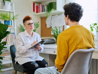 Female professional psychologist mental therapist working with young guy in office. Social worker counselor psychotherapist helping patient with difficulties stress depression. Psychology psychotherapy